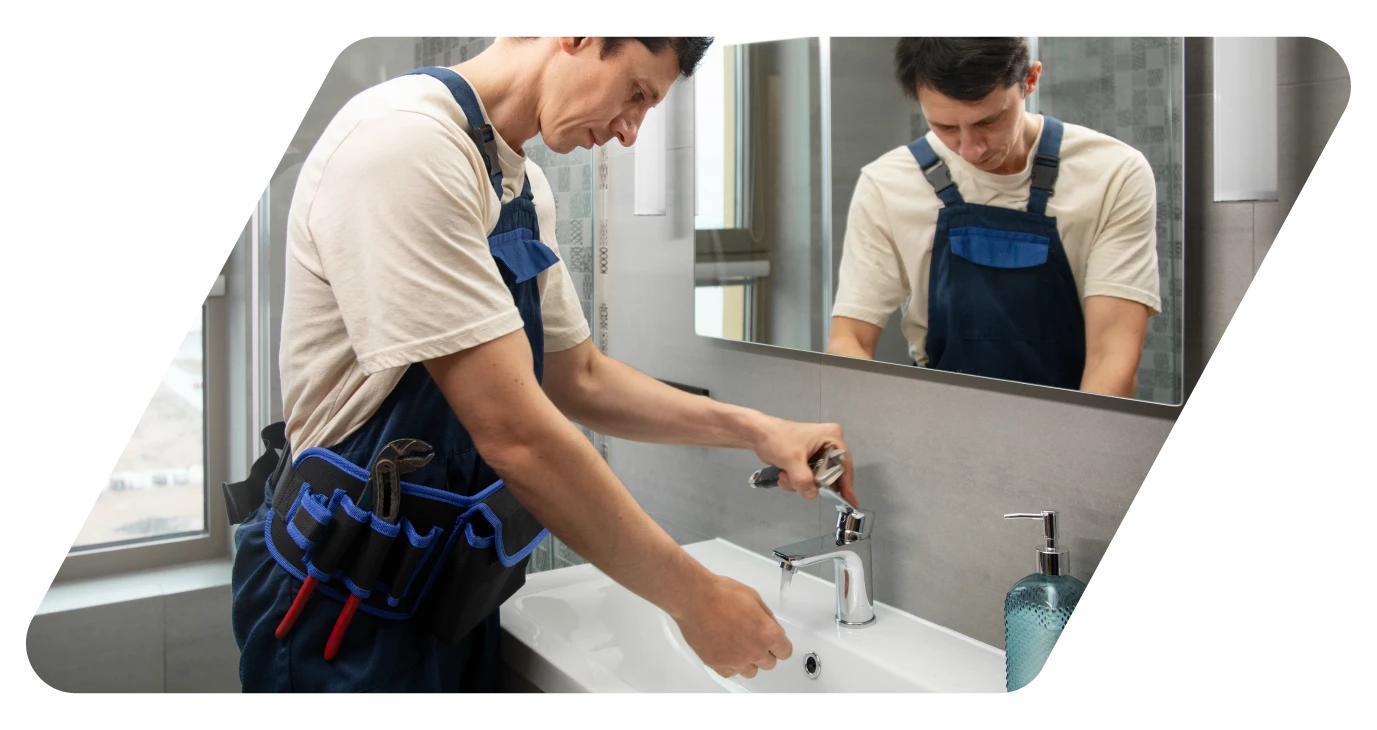 Image d'un plombier qui installe un robinet de lavabo