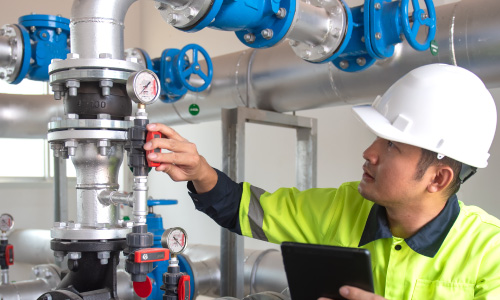 Image d'un technicien contrôlant la pression d'une installation avec un manomètre