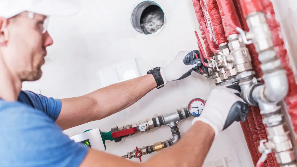 Image d'un professionnel qui manipule un robinet à boisseau sphérique sur une installation