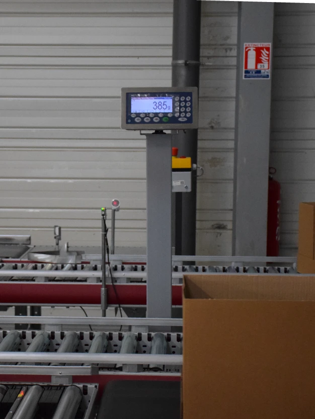 Un carton passe sur une balance pour vérifier son poids